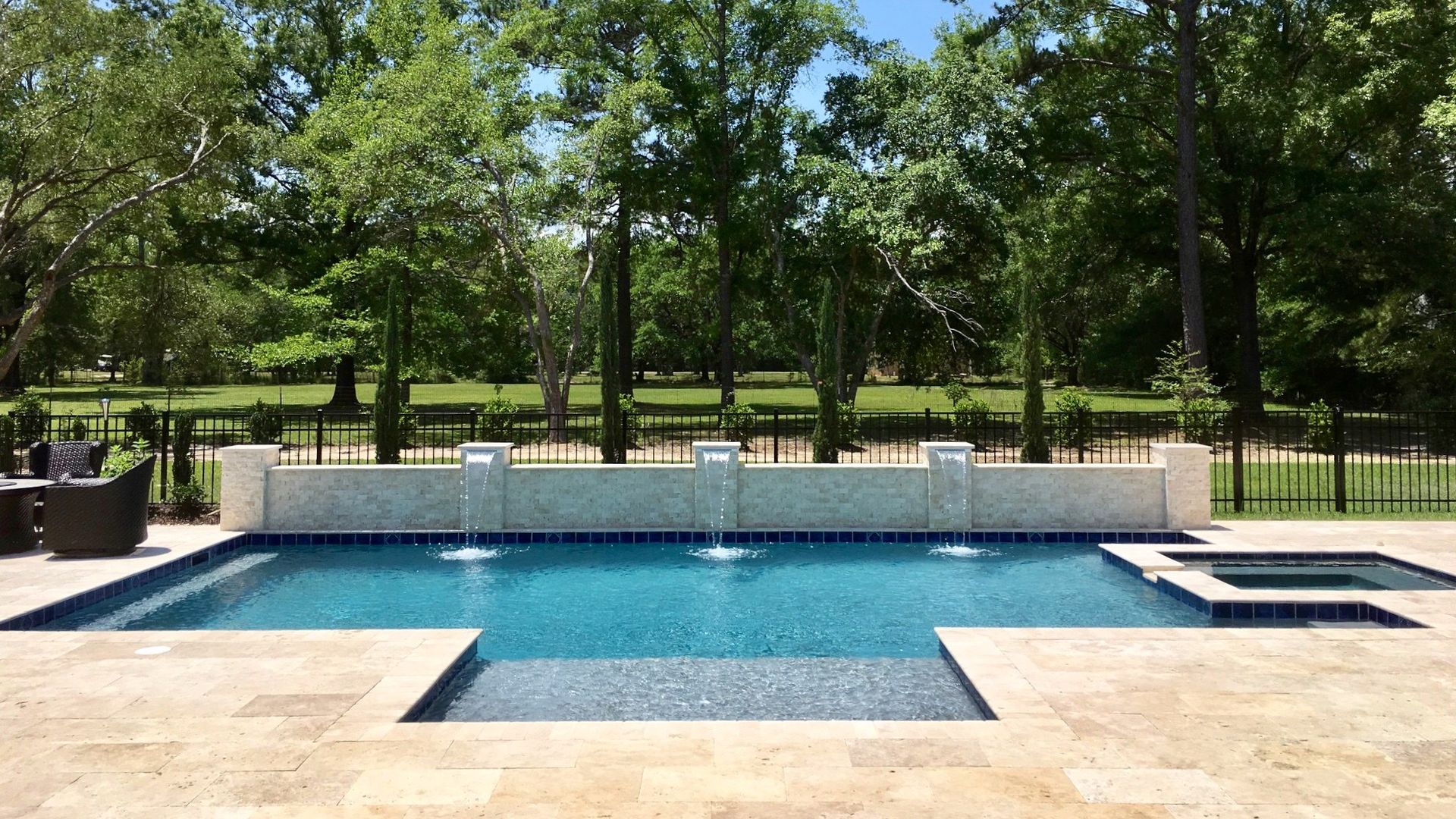 Geometric pool with a sheer-descent wall, spa, and tanning ledge